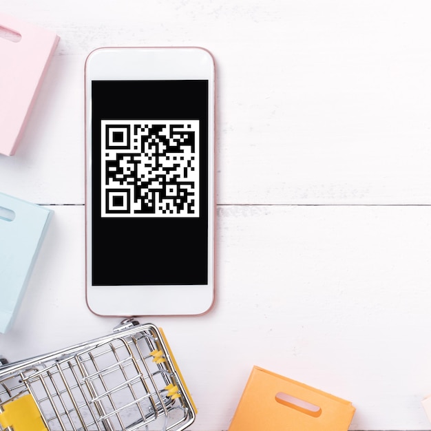 Abstraktes Online-Shoppingmobile Zahlung mit QR-Code-Designkonzeptelementbunte KarrePapiertüte auf HolztischhintergrundDraufsichtflache Lage