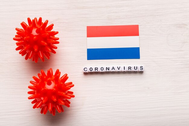 Abstraktes Virusstammmodell des Atmungssyndroms Coronavirus 2019-nCoV im Nahen Osten oder des Coronavirus COVID-19 mit Text und Flagge Niederlande auf Weiß