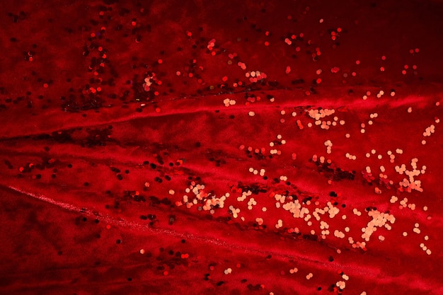 Abstraktes Weihnachtshintergrund aus rotem Samtstoff mit roten Funkeln
