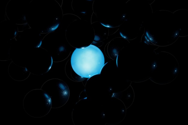 abstrato. bolas de néon azuis brilhantes em uma massa disforme preta.