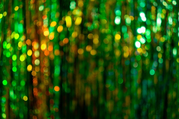 Abstrato de natal verde. bokeh luzes. decoração de férias de inverno. círculos laranja dourados brilhantes desfocados. desfoque a textura de ouropel de brilho brilhante. a discoteca da noite da festa de ano novo brilha.