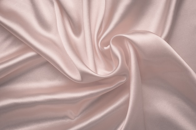 Abstrato de seda. tecido macio rosa brilhante. textura delicada rosa têxtil. dobras de cetim, padrão de ondas. pano de fundo de seda pastel com curvas, moda de luxo.