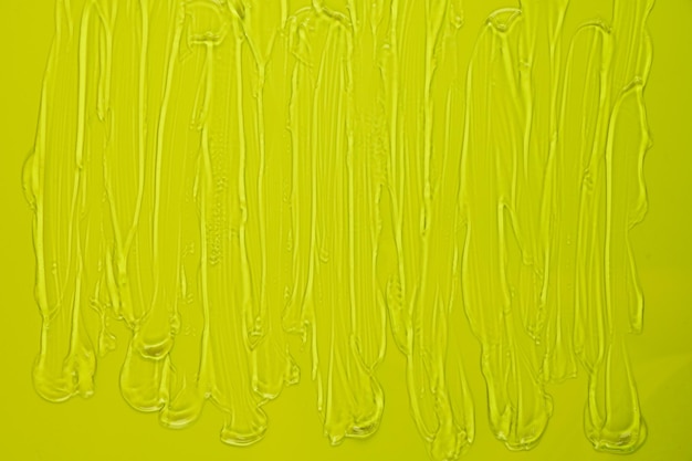 Abstriche von transparentem Gel auf grünem Hintergrund Cremige Textur des Hygiene-Hautpflegeprodukts