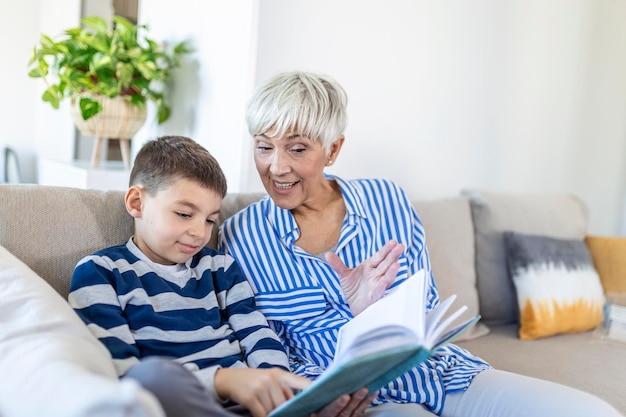 Abuela amorosa enseñando a su nieto sosteniendo un libro sentado en el sofá, abuela niñera abrazando a un niño leyendo un cuento de hadas a un niño lindo, niñera abuela contando una historia a un nieto en edad preescolar