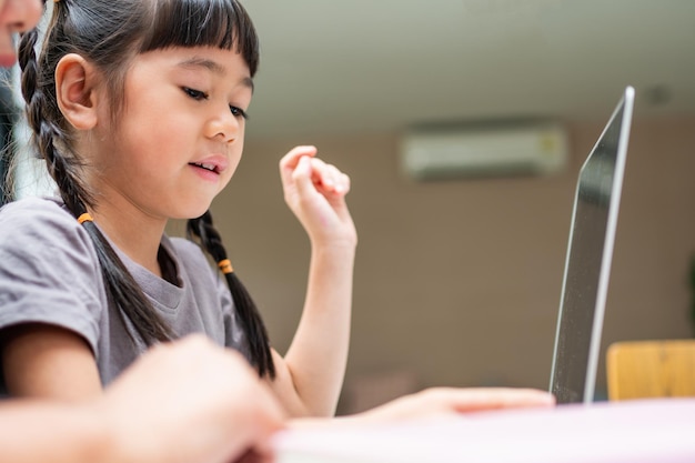 Abuela asiática con sus dos nietos divirtiéndose y jugando juegos educativos en línea