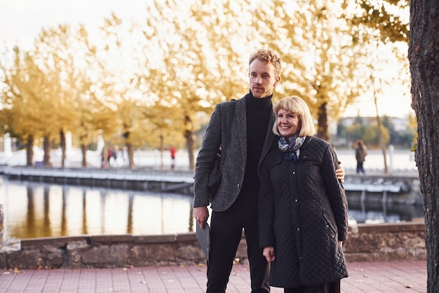 Abuela con chico joven en ropa formal en un parque de otoño. | Foto Premium