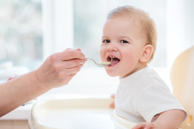 La abuela le da comida a su bebé con una cuchara