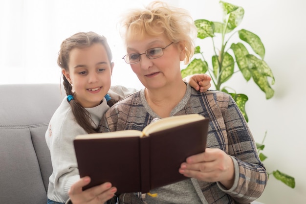 La abuela está leyendo un libro a su nieta.