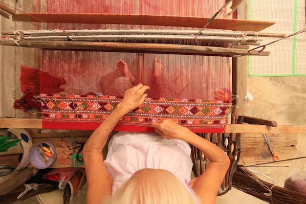 La abuela está tejiendo en la provincia de Chainat, Tailandia.