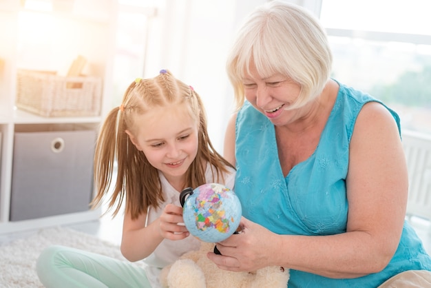 Abuela feliz mostrando globo a nieta