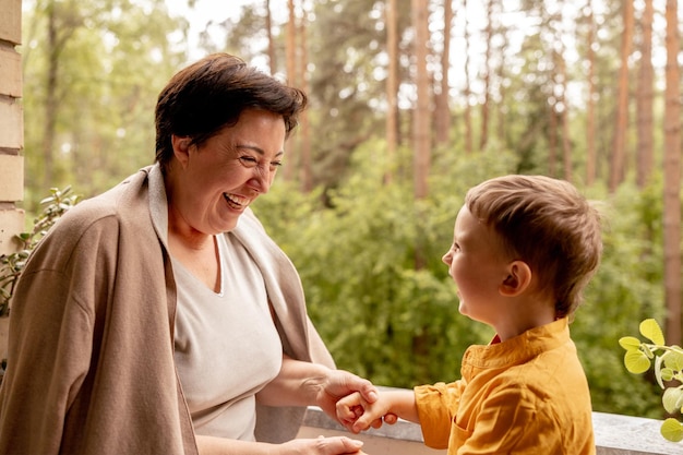 Abuela feliz y nieto disfrutan del tiempo juntos Mujer positiva de mediana edad jugando con un pequeño y lindo nieto riéndose divirtiéndose Abuela de 50 años con nieto Familia multigeneracional