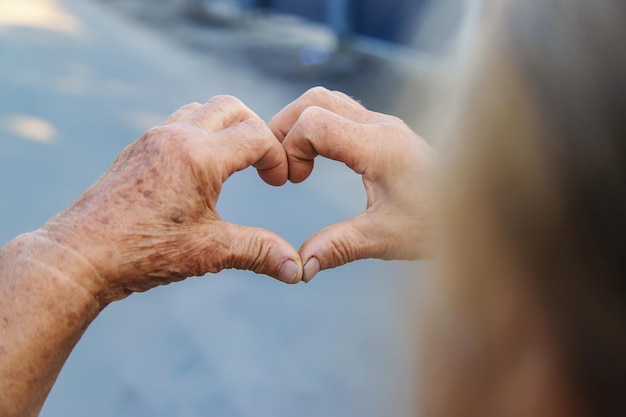 La abuela hace un corazón con sus manos Enfoque selectivo