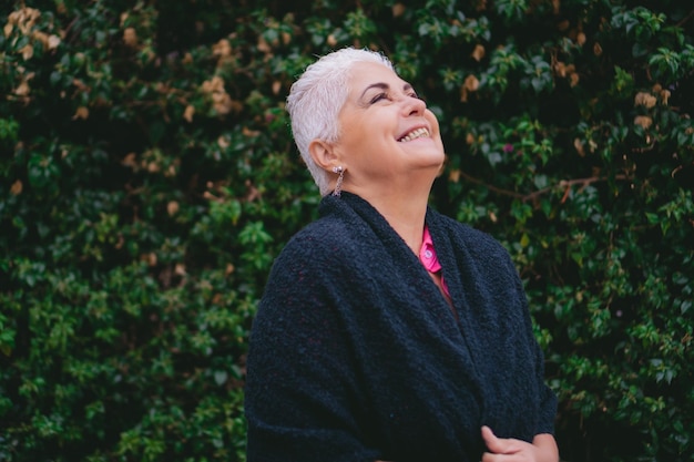 Foto abuela latina mayor con un poncho o ruana ríe espacio para copiar