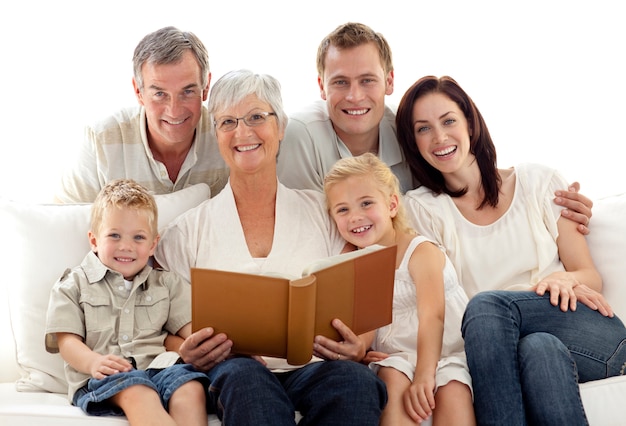 Abuela leyendo un libro a sus hijos y padres