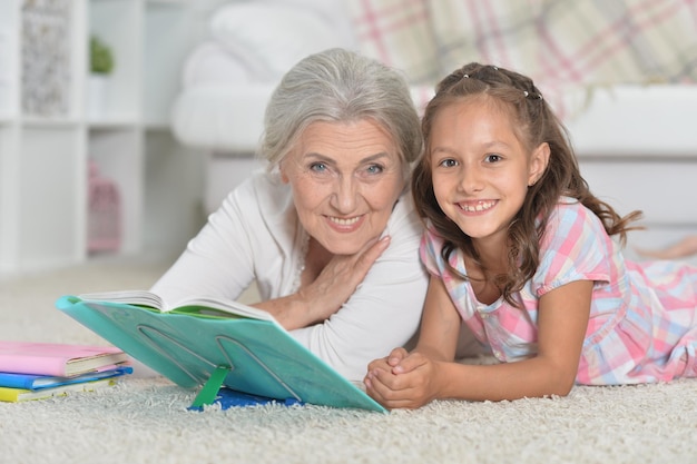 Abuela con linda niña haciendo la tarea juntos