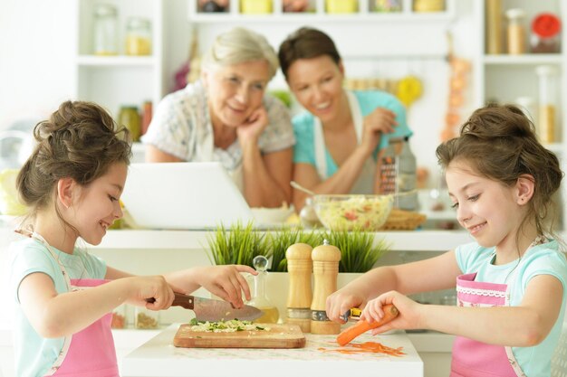 Abuela, madre y dos hijas cocinan el desayuno