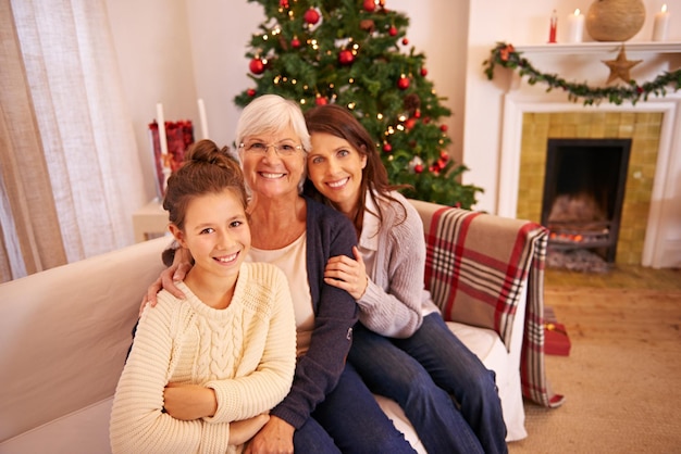 Abuela madre y niña en el sofá en Navidad disfrutando de las vacaciones y la celebración del festival Amor familiar y retrato de mamá uniéndose con la abuela y el niño con el árbol de Navidad en casa