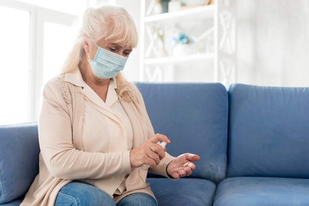 Abuela con mascarilla con desinfectante