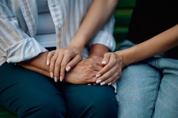 Abuela y nieta en un banco en el parque de verano