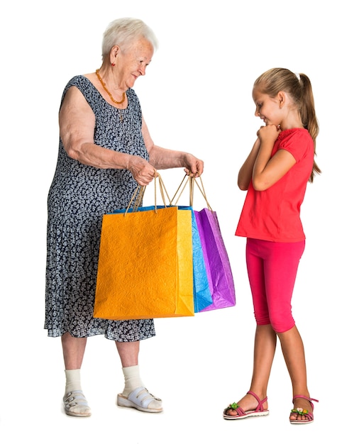 abuela con nieta con bolsas de la compra.