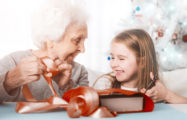 Abuela con nieta decorando regalos