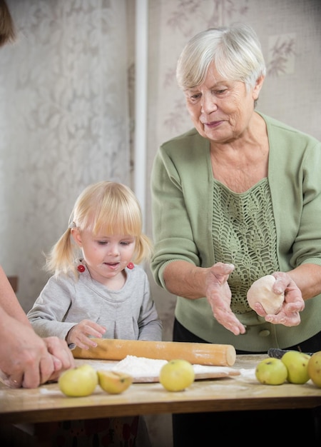 Una abuela y una nieta están haciendo pequeños pasteles Retrato