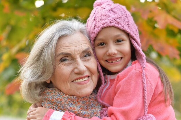 Abuela y nieta felices en parque otoñal