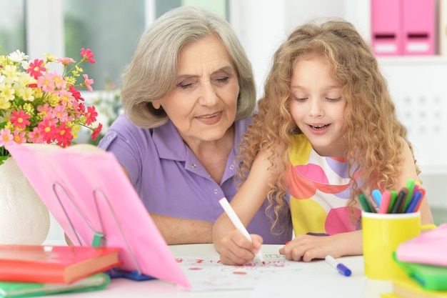 Abuela y nieta haciendo los deberes, juntos en casa