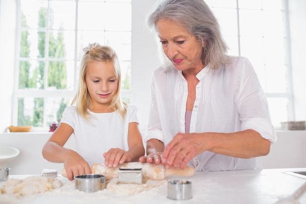 Abuela y nieta haciendo galletas juntos