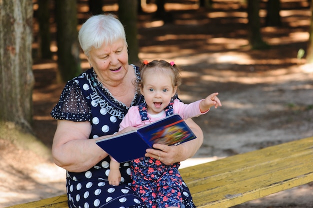 Abuela y nieta leyendo el libro en el parque