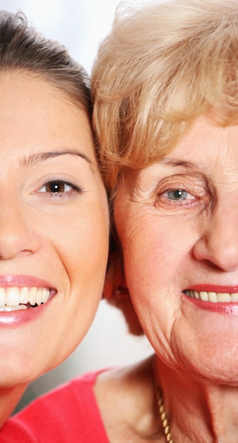 una abuela y una nieta sonriendo sobre fondo brillante