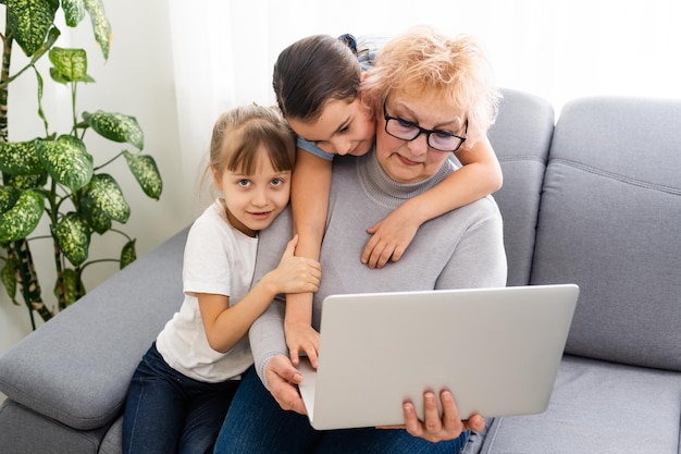 La abuela con la nieta usa una computadora portátil y aprende a contar juntos en casa.