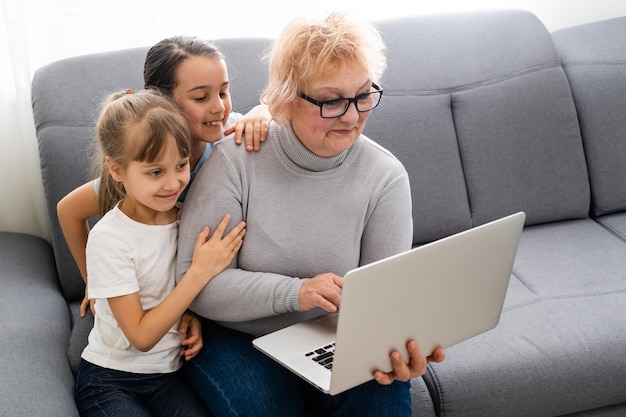 La abuela con la nieta usa una computadora portátil y aprende a contar juntos en casa.