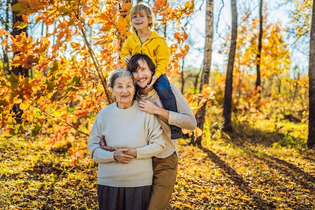 Abuela y nieto adulto abrazándose en el parque de otoño