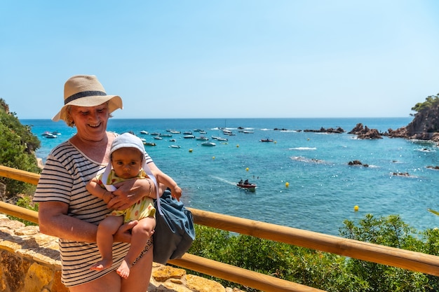 Una abuela y un nieto divirtiéndose en el verano en Cala Canyet junto al pueblo de Tossa de Mar. Girona, Costa Brava en el Mediterráneo