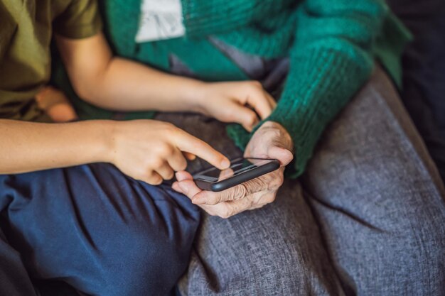 Abuela y nieto están mirando un teléfono inteligente