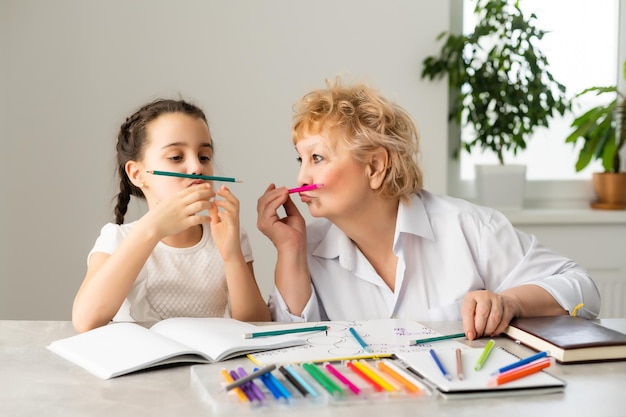 Abuela con niña haciendo los deberes.