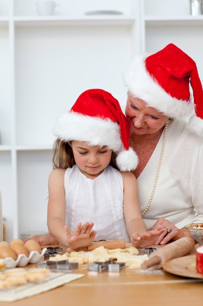 Abuela y niña hornear tortas de Navidad