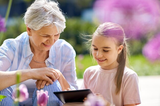abuela y niña con tableta en el jardín