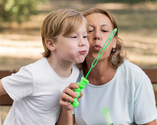 Foto abuela y niño haciendo globos.