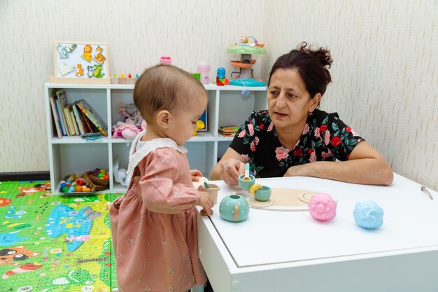 Abuela y niño jugando con juguetes en casa