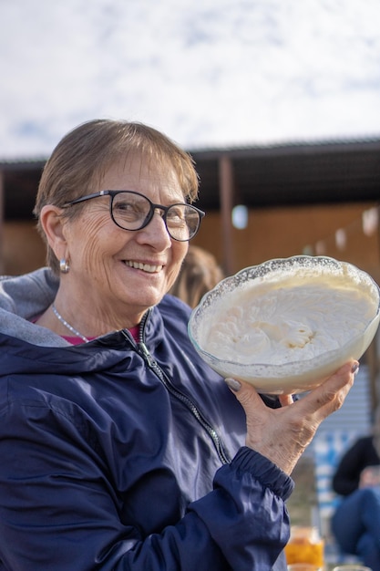 Abuela sonriendo mostrando un bol con crema casera