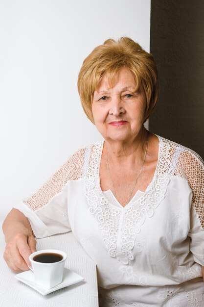 Foto la abuela sonriente bebiendo café