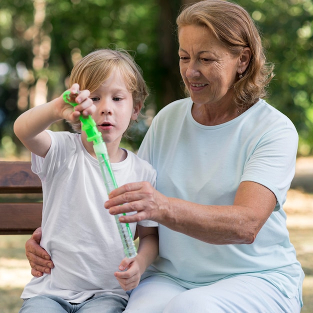 Foto abuela sonriente y niño en un banco