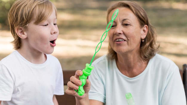 Abuela sonriente y niño haciendo globos