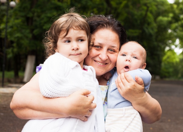 Foto abuela con sus nietos en un parque. retratos de familia