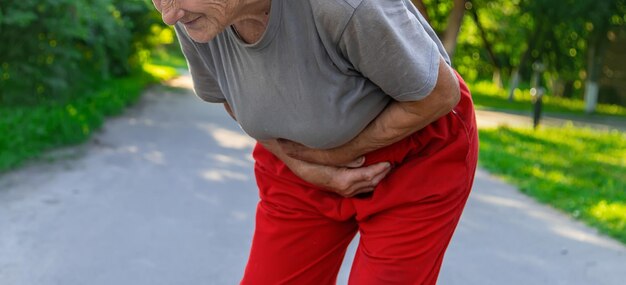 La abuela tiene dolor de estómago en el camino Enfoque selectivo