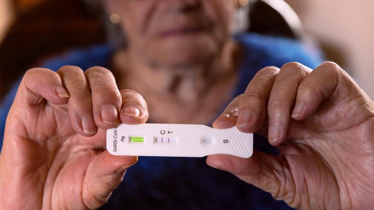 Foto una abuela triste fabrica un dispositivo de prueba rápida en el hogar para el virus covid19 con un resultado positivo