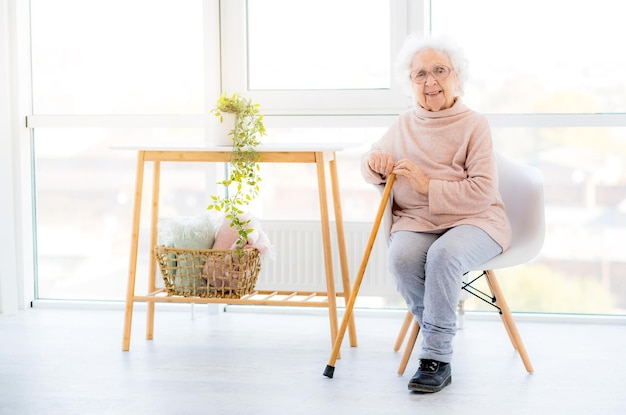 Abuelita sonriente sentada en una silla