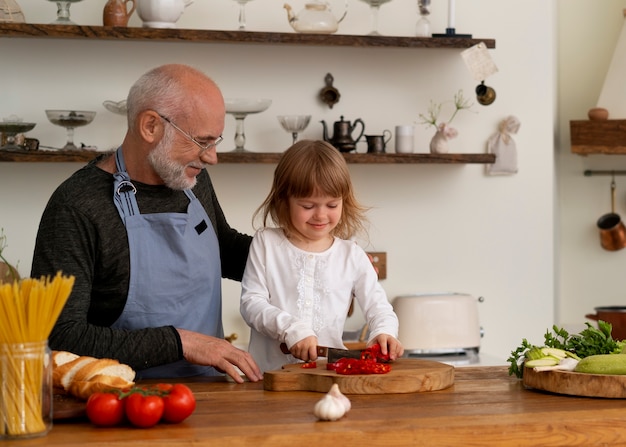 Foto abuelo cocinando en la cocina con su nieto